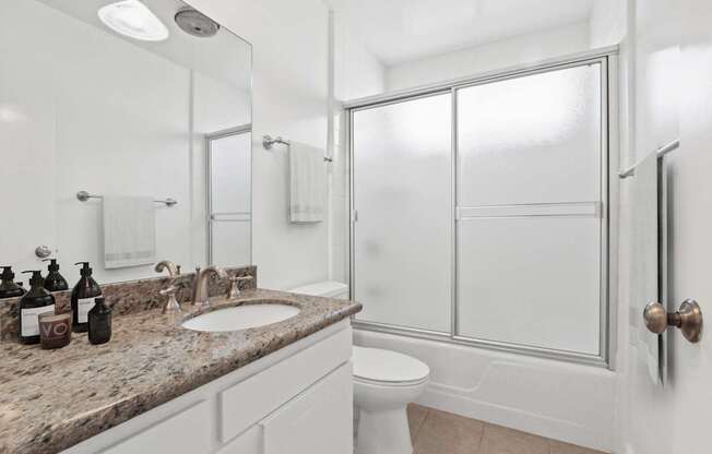 A bathroom with a sink, toilet, and shower.