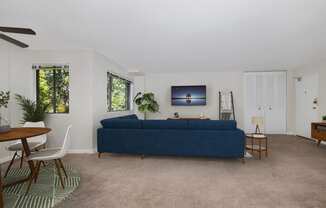 a living room with a blue couch and a dining room table