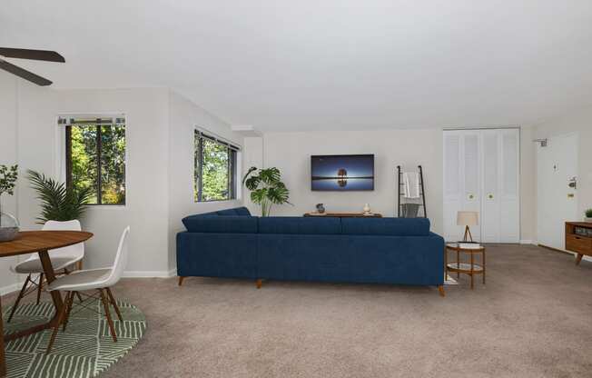 a living room with a blue couch and a dining room table