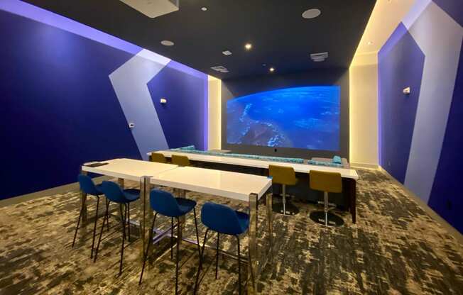 a conference room with a table and chairs and a large screen at Icon One, Daytona Beach, FL, 32114