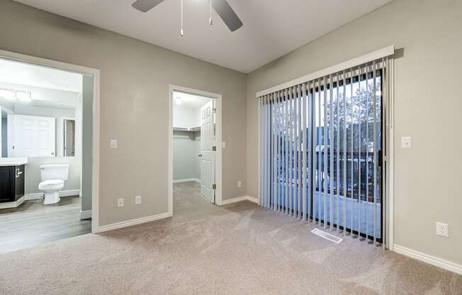 an empty living room with a large window and a ceiling fan at Ashford Belmar Apartments, Lakewood, CO