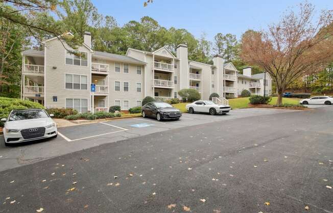 A parking lot with cars and apartment buildings in the background.