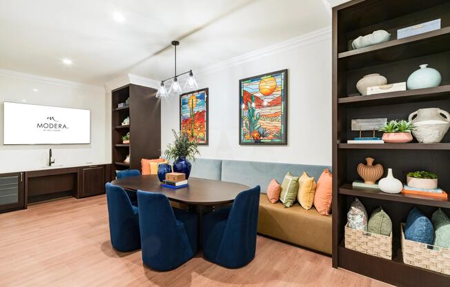 Community dining nook with built-in banquette seating, curated shelving, and a shared table designed for casual meals and small gatherings.