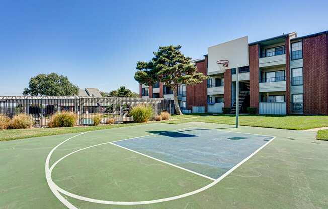 a basketball court in front of an apartment building