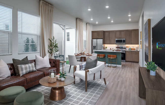 A modern living room with a brown leather couch and a television on the wall.