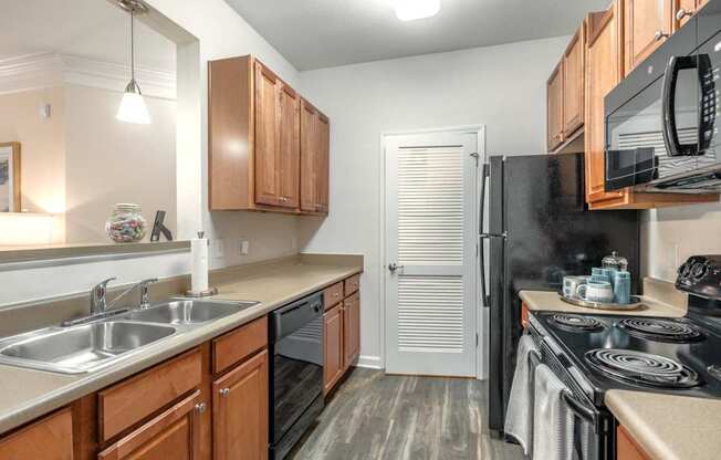 A kitchen with wooden cabinets and black appliances.