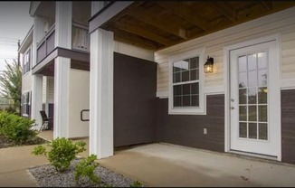 A house with a white door and a small garden in front.