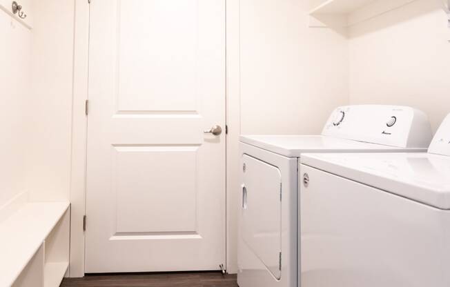 a laundry room with a washer and dryer and a white door