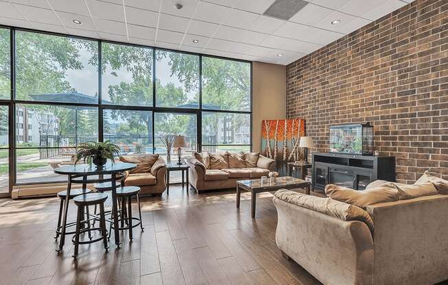 a living room with couches and a table in front of a wall of windows