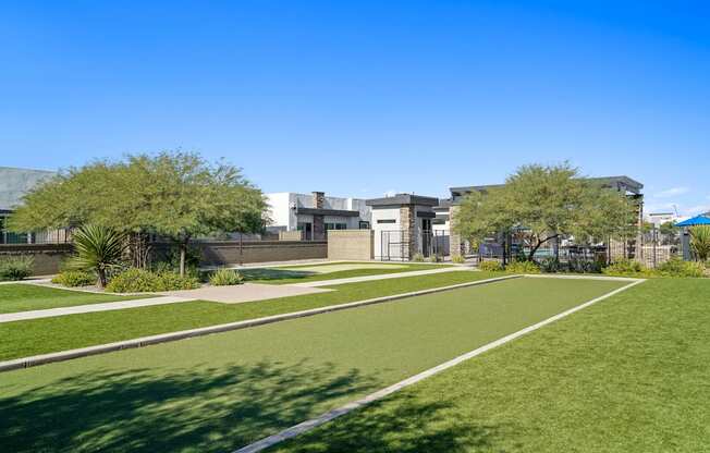 a park with grass and trees and buildings in the background