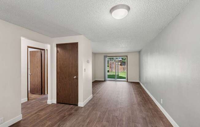 A room with wooden floors and two doors.