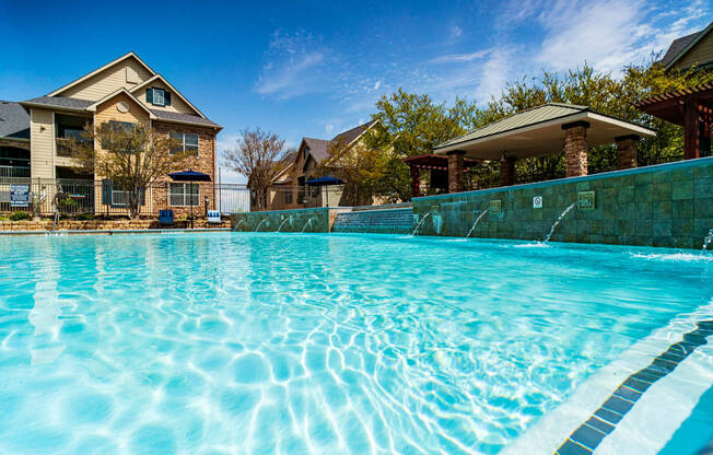 apartments with a large swimming pool in front of a house