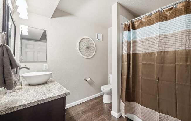 a bathroom with a shower and a toilet and a sink