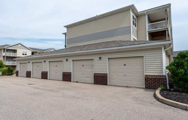 a garage with a row of white doors on the side of a house