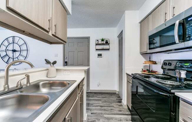 a kitchen with a sink and a stove and a microwave