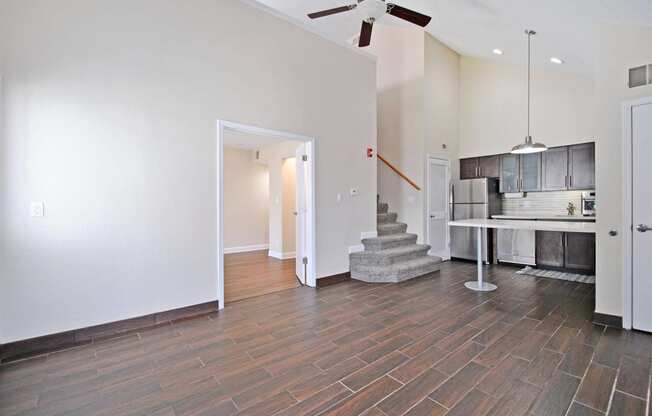 the living room and kitchen of a new home with a ceiling fan