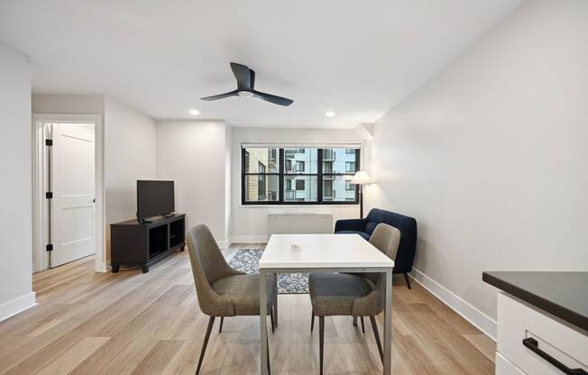 a living room with a white table and chairs and a tv