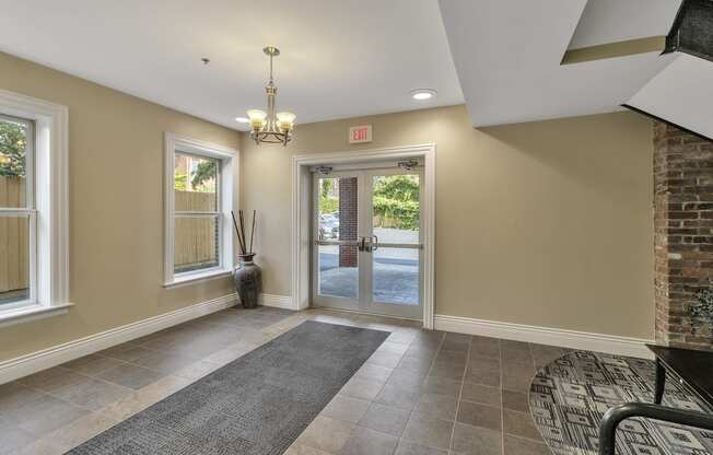 an empty entryway with a brick wall and a glass door