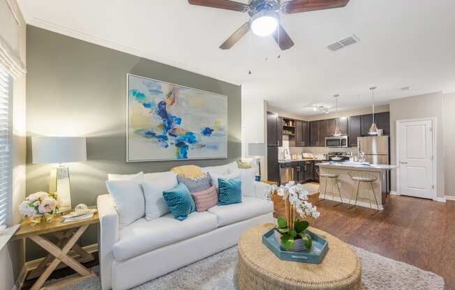 an open living room and kitchen with a ceiling fan