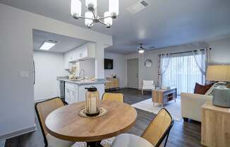 A well-lit dining area with a round wooden table and chairs.