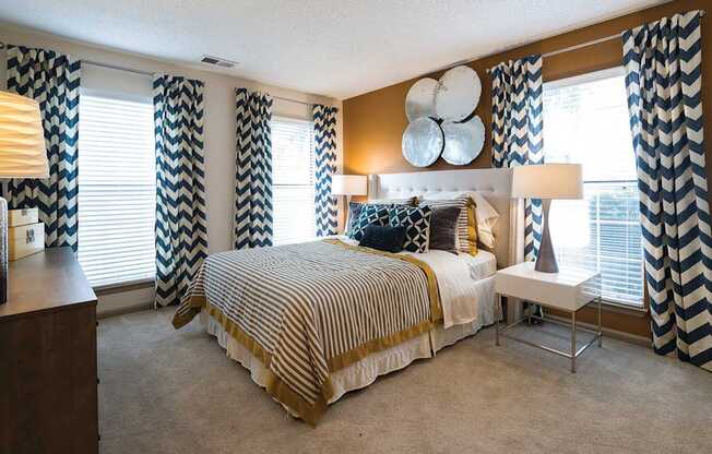 A bedroom with a large bed and a chair.