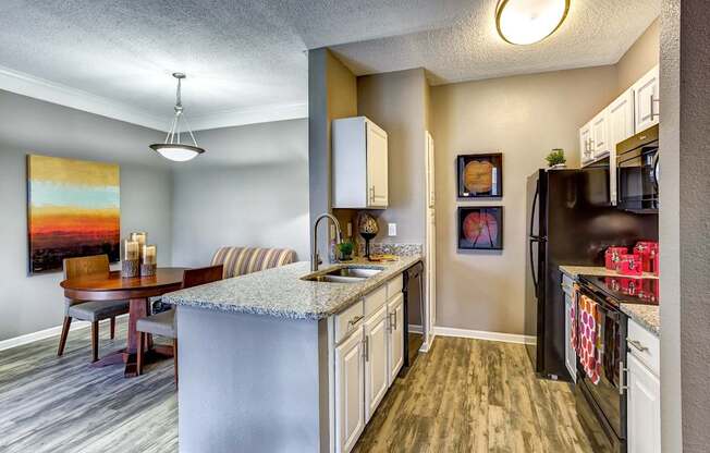 Upgraded model kitchen and dining room with granite countertops and black Whirlpool appliances