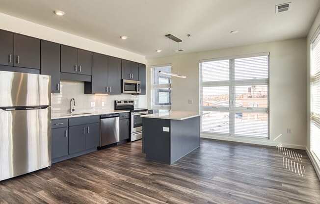 an empty kitchen with stainless steel appliances and a large window