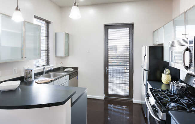 Granite Kitchen Island Stainless Steel Appliances with Cork and Polished Concrete Flooring and a Private Balcony