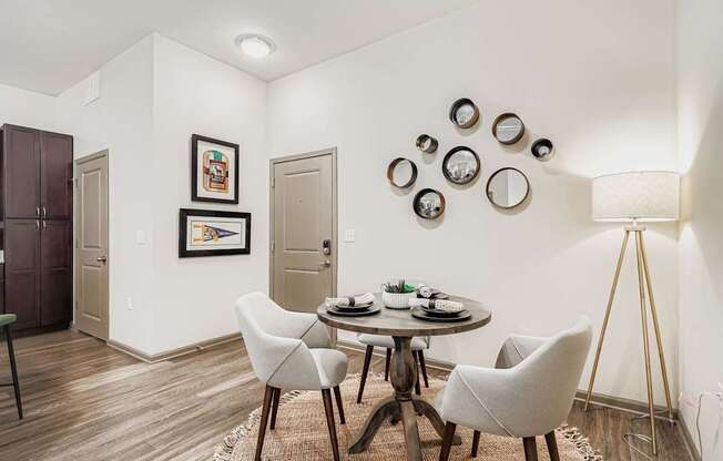 A dining room with a round table and chairs.