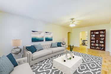 living area with seating area, coffee table, bookshelf, hardwood flooring and ceiling fan at meridian park apartments in washington dc