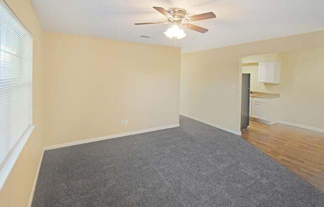A room with a ceiling fan and carpeted floor.