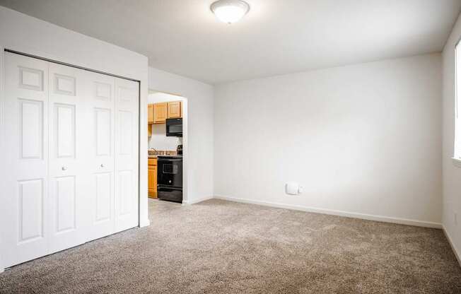 A room with a white door and a brown carpet.