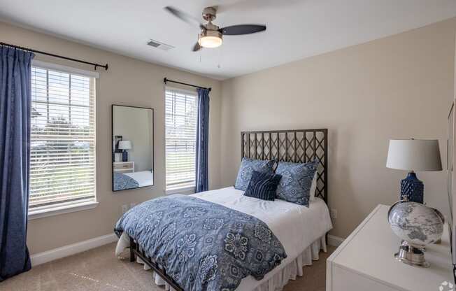 a bedroom with a bed and a ceiling fan