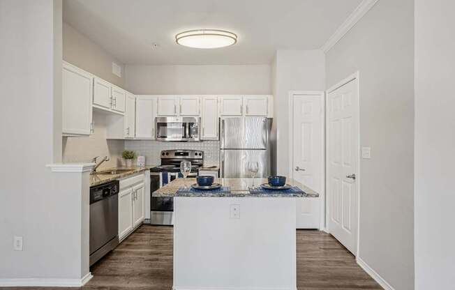 A kitchen with white cabinets and a white island.