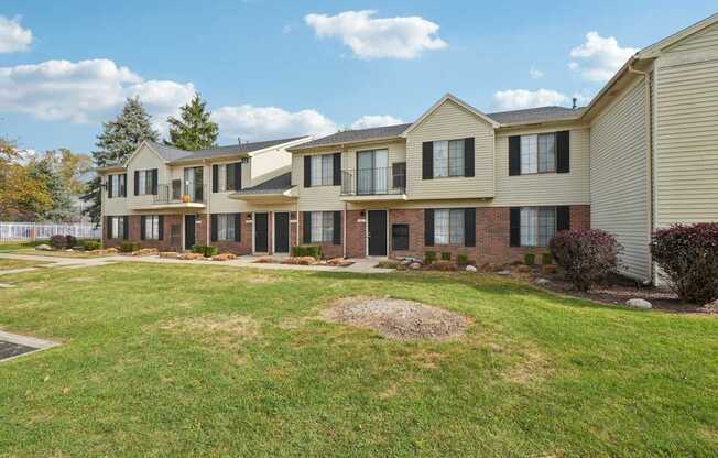 A row of houses with a grassy area in front.