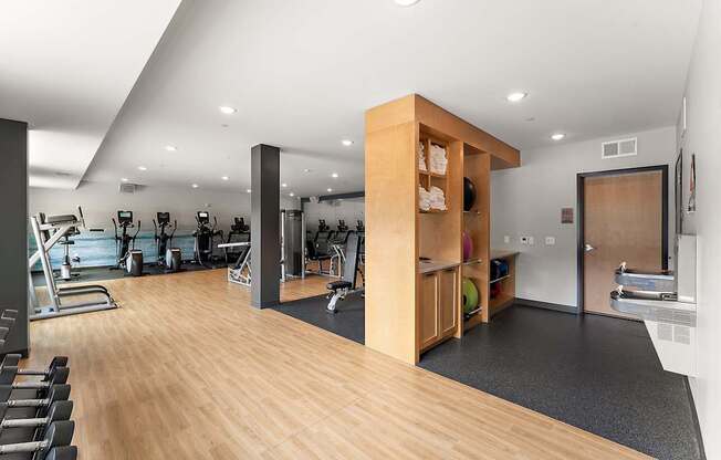 A gym with a variety of equipment including treadmills, weights, and exercise machines.