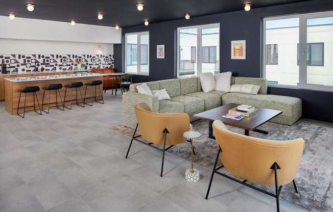 A living room with a grey floor and a white wall with a black and white mural.