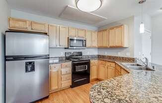 a kitchen with granite counter tops and stainless steel appliances