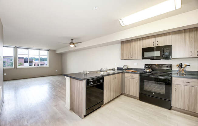 A kitchen with black appliances and wooden cabinets.