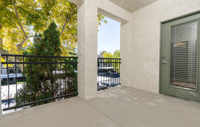 the view from the balcony of a condo with a green door and a balcony railing