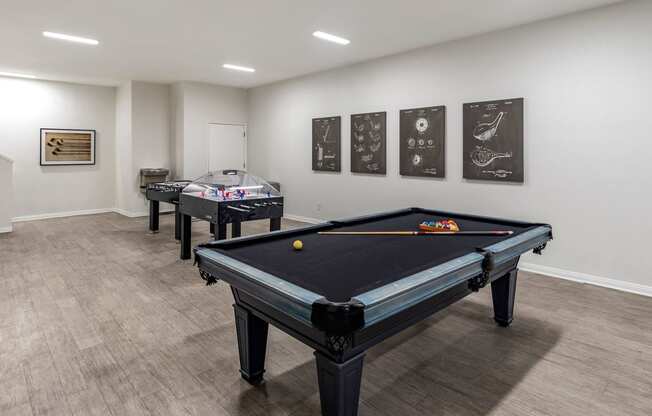 a game room with two pool tables and two foosball