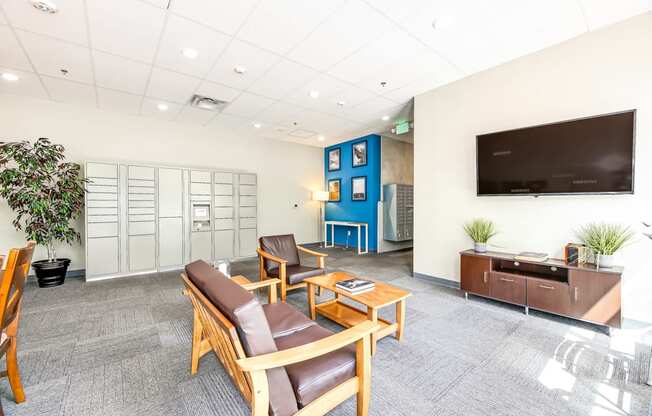 A waiting room with brown leather chairs and a flat screen TV mounted on the wall.