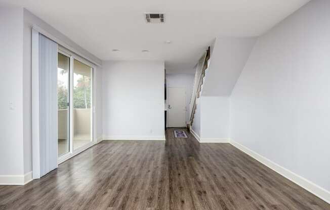 an empty living room with white walls and wood floors