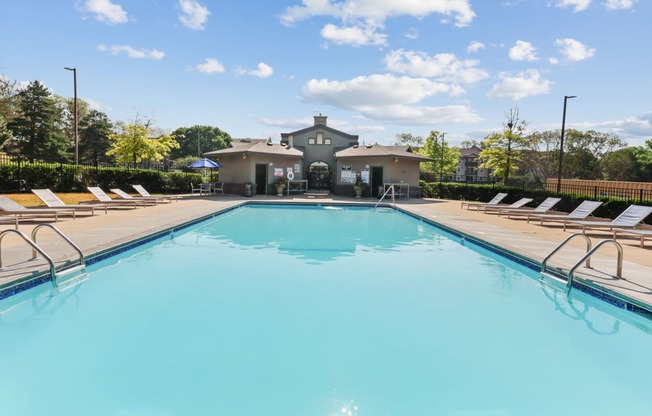 a swimming pool with lounge chairs and a building in the background