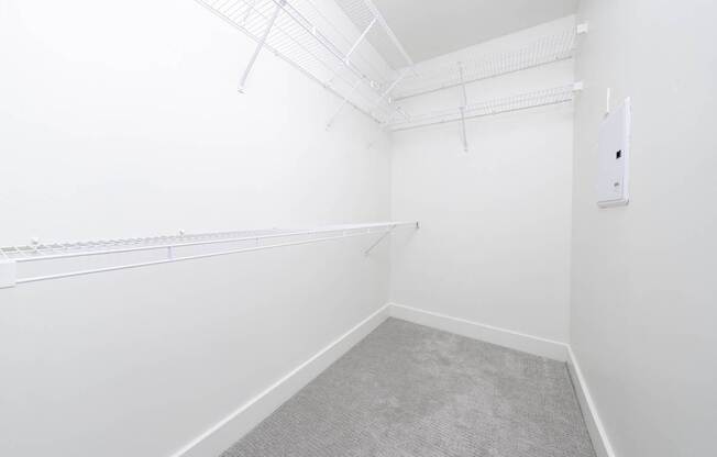A white room with a grey carpet and a white wall.