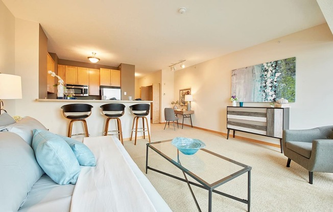 A living space with a white couch and a glass coffee table.