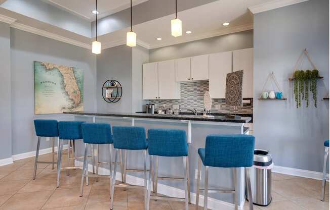 a kitchen with a bar and stools in front of it