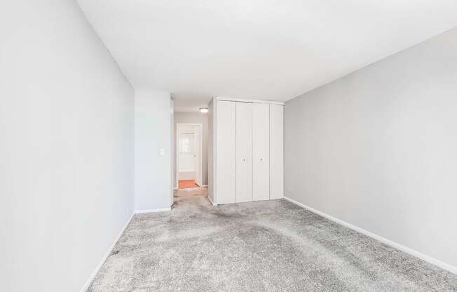 a bedroom with grey carpet and white walls