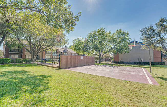 A sunny day at the park with a basketball court.