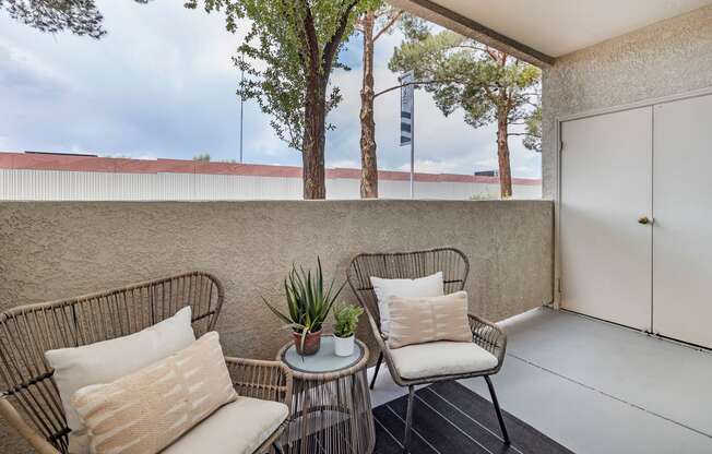 a balcony with two chairs and a table at Paisley and Pointe Apartments, Las Vegas, NV 89130